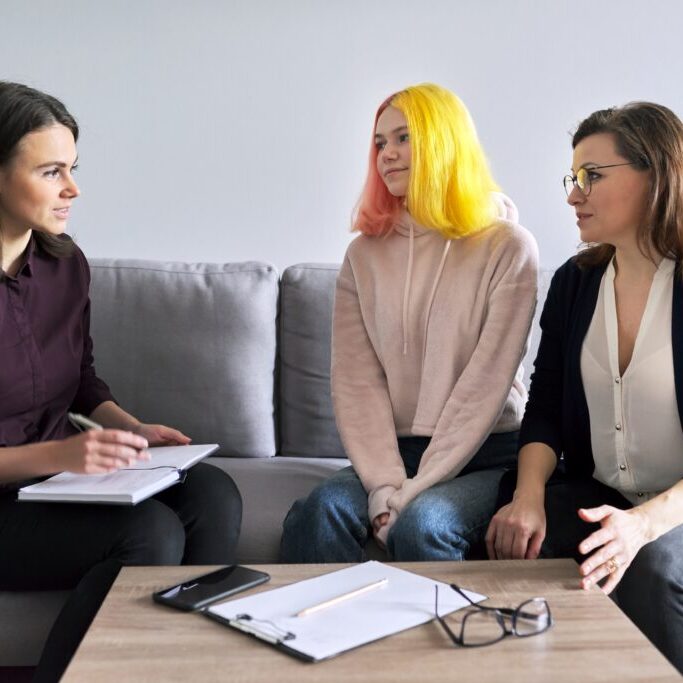 Social worker, psychologist, counselor at meeting with mature woman and her teenage daughter. Psychology, family mental health, adolescence problems, mother daughter child parent relationships